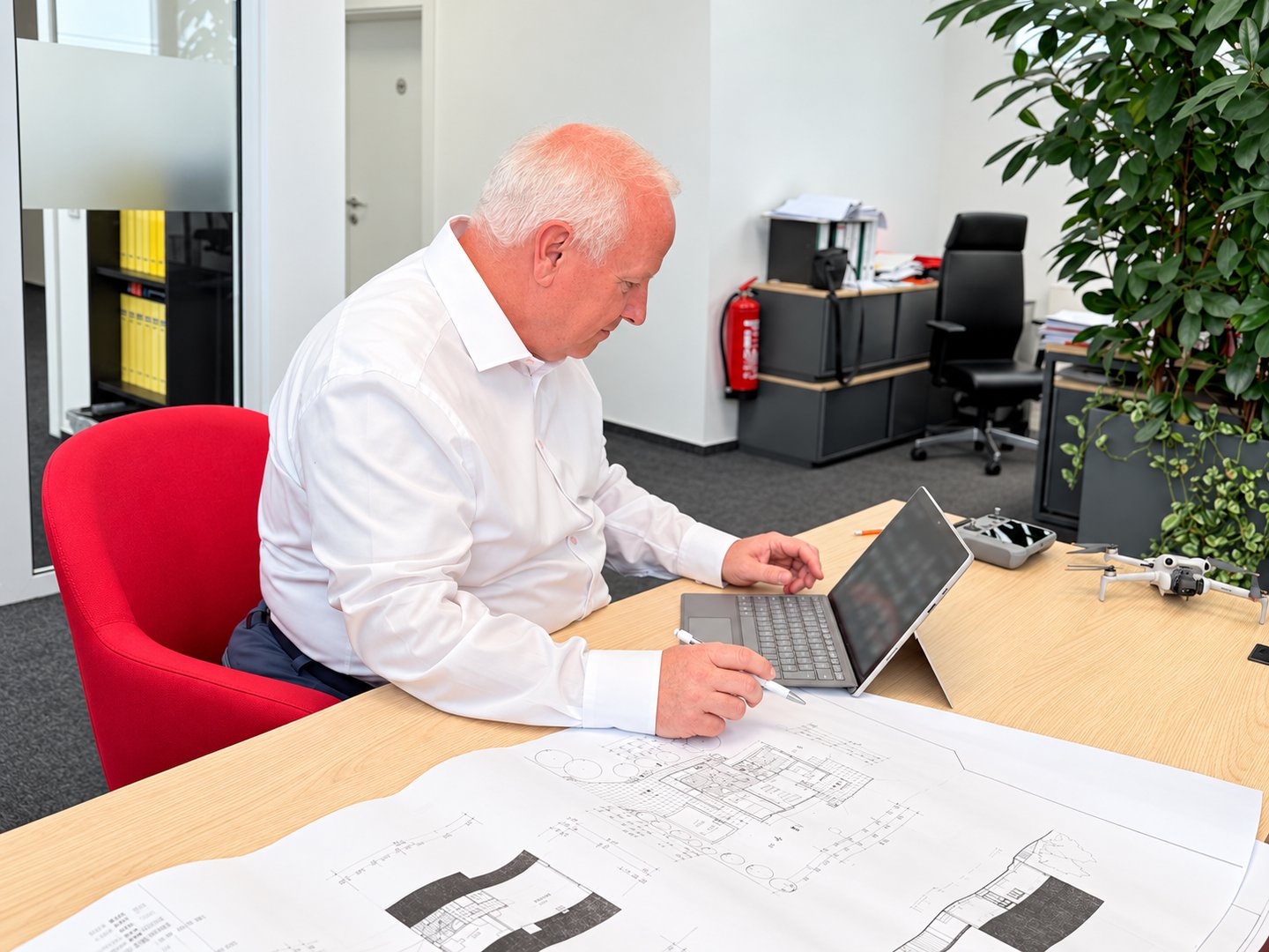 Frank Bechtel mit Laptop und Unterlagen am Schreibtisch